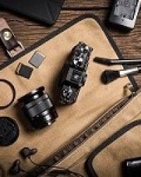 photography gear on wooden table, digital camera lens and other accessories.